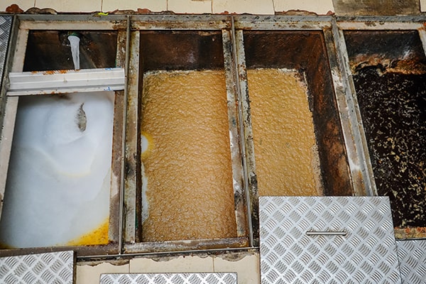 signs that a grease trap needs maintenance include slow drainage, foul odors, and visible grease accumulation